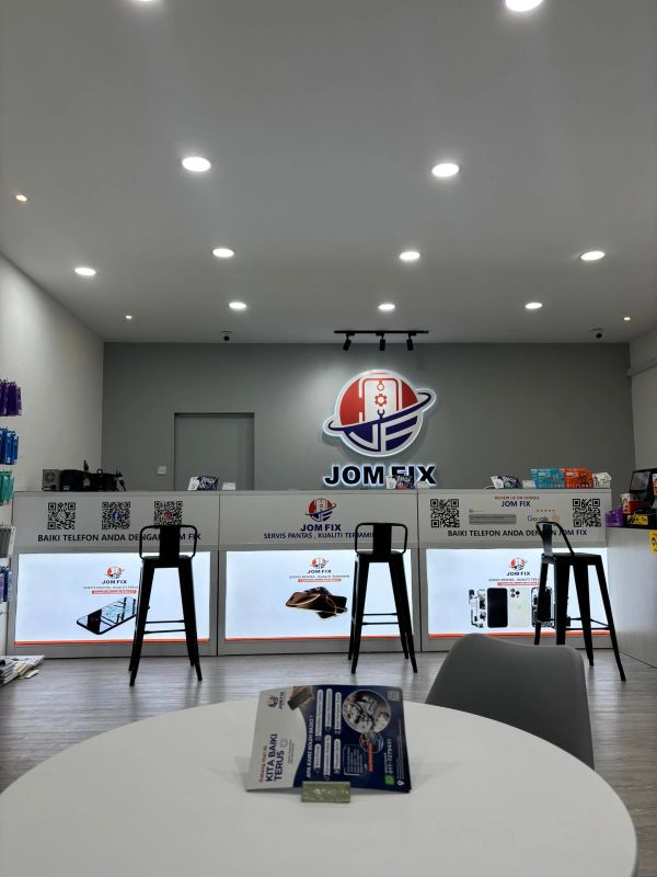 Modern phone repair shop interior with stools and a round table.