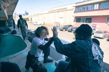 Two people sharing a high-five outside in an urban setting.