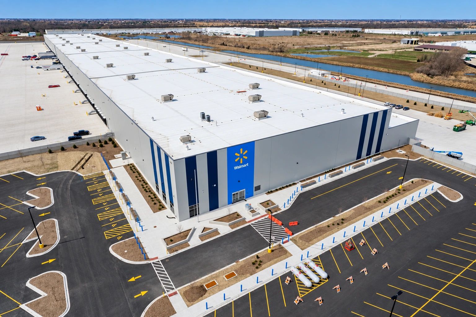 Aerial view of a distribution warehouse, loading docks, access roads, and parking areas.