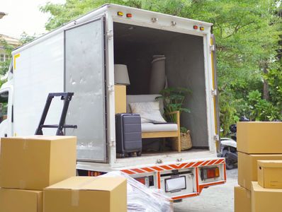 Moving truck loaded with furniture and boxes outdoors.