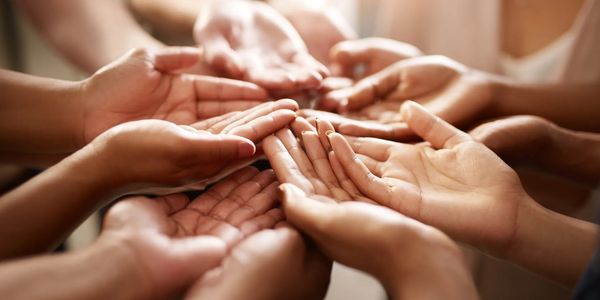 Multiple hands reaching inward, symbolizing unity and support.