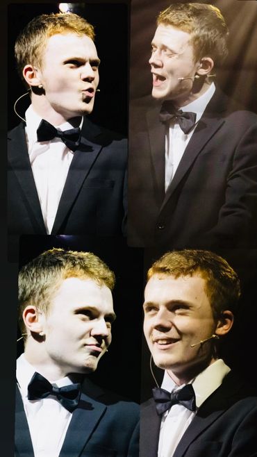 Young man in tuxedo performing on stage with expressive emotions.