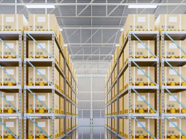 Warehouse aisle with shelving and stacked boxes.
