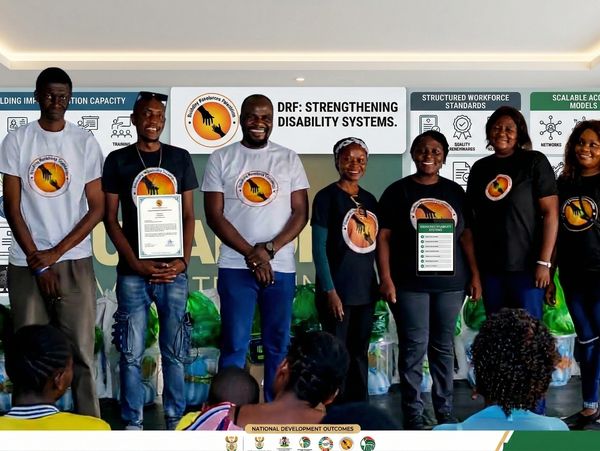 Group of seven people wearing matching logo shirts at a disability systems event.