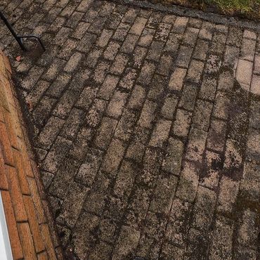 Dirty block paving patio which needs to be pressure washed.