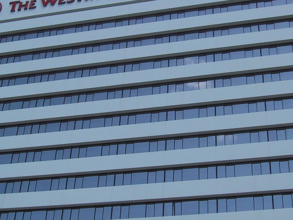Modern building with reflective glass windows and white horizontal panels.