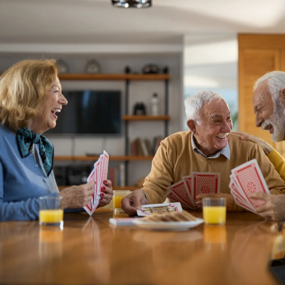 Seniors enjoying a card game together at home.