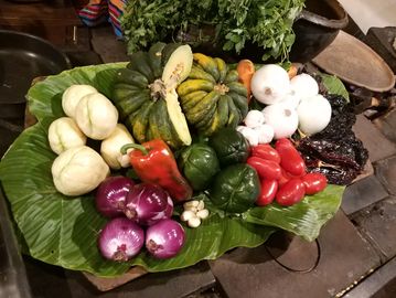 Colorful fresh vegetables arranged on a large green leaf.