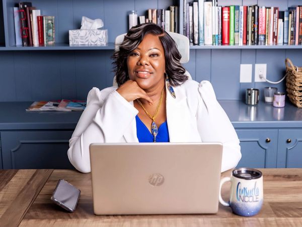 Confident woman at desk with laptop and mug.
