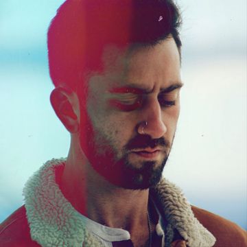 Man with closed eyes and beard in a warm jacket.