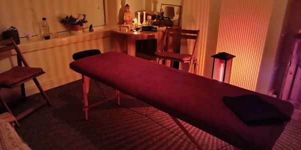 Massage table set up in room with soft lighting