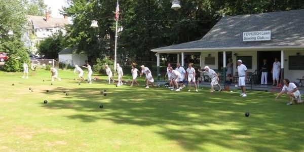 People playing lawn bowling on a sunny day at a bowling club.