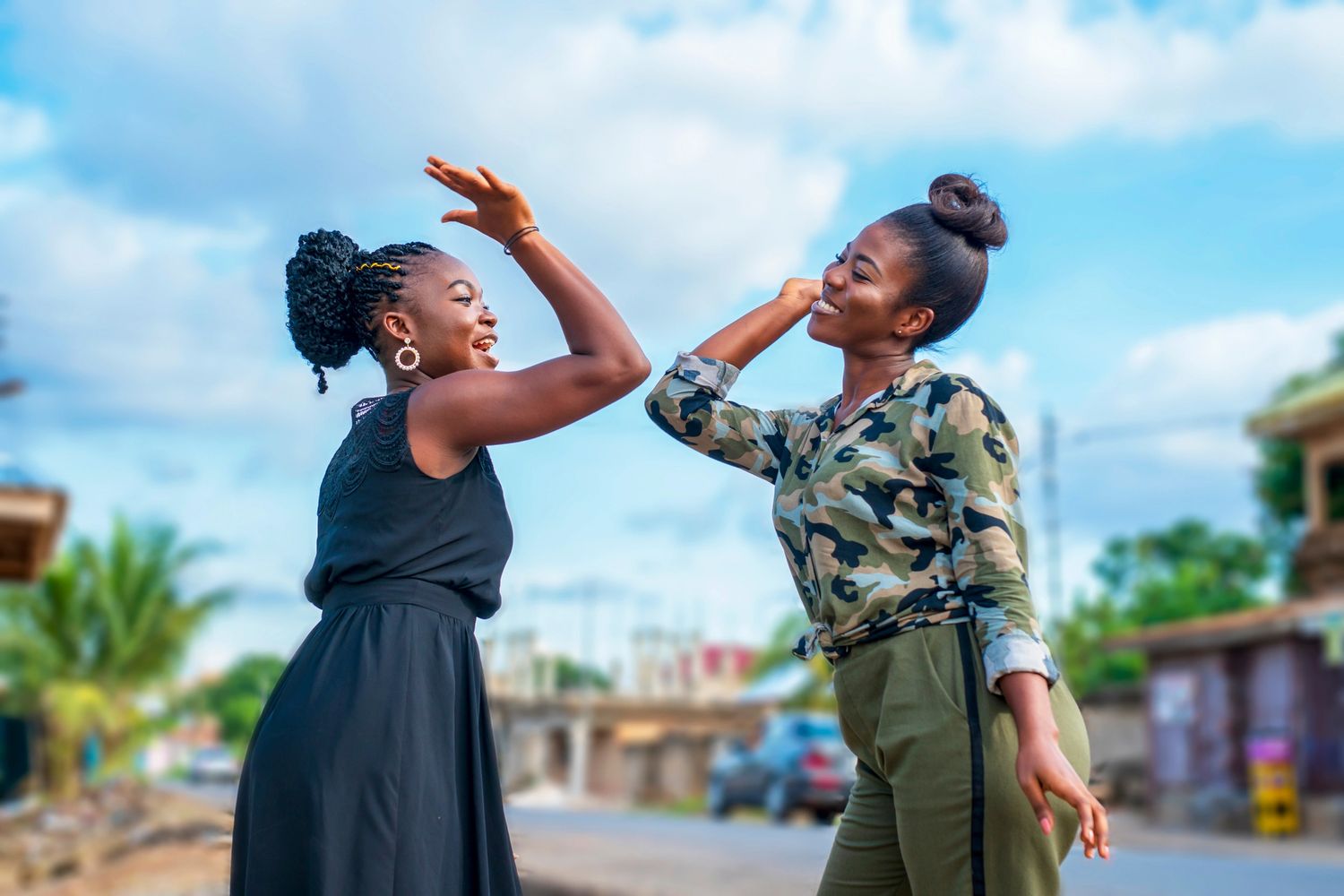 Two beautiful African women happily laughing and giving a high five
