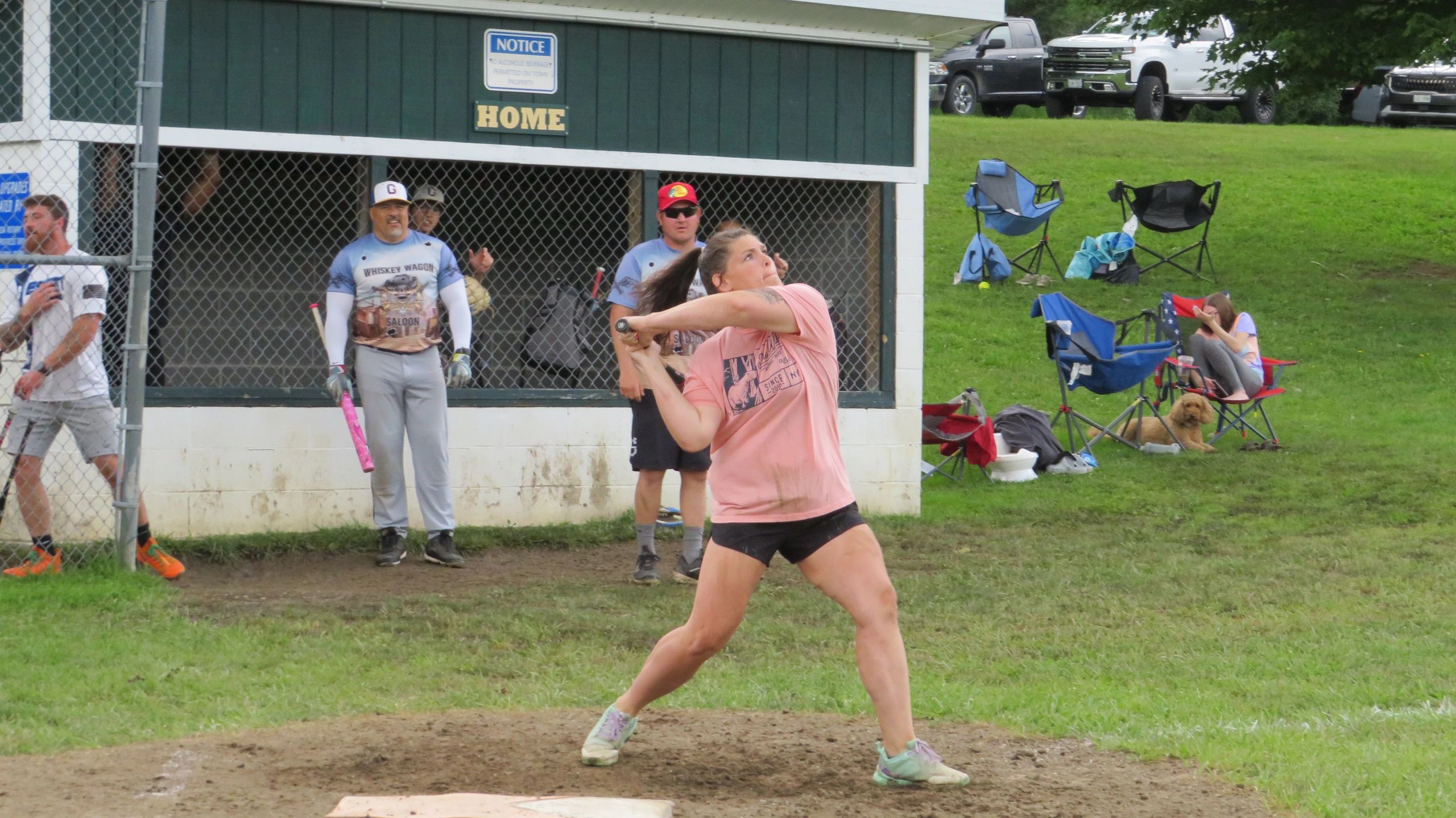 Woman swinging a bat during a softball game.