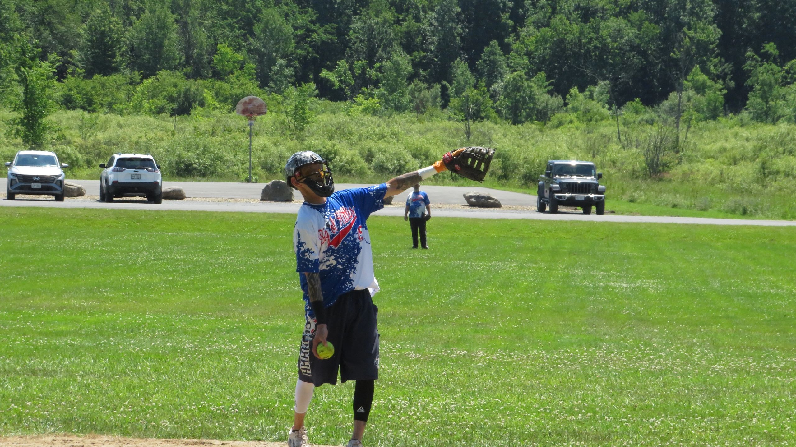 A person in sports gear playing softball on a grassy field.