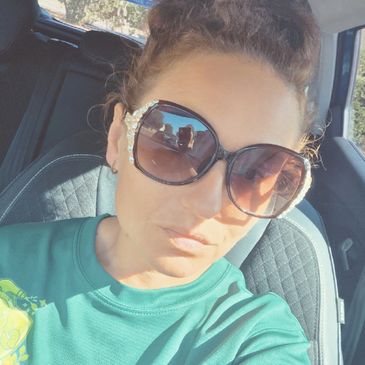 Woman wearing large sunglasses in a car.