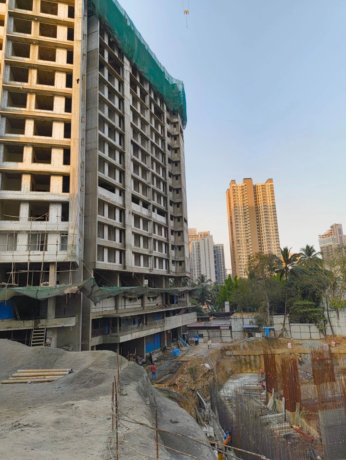 High-rise building under construction with scaffolding and safety nets.
