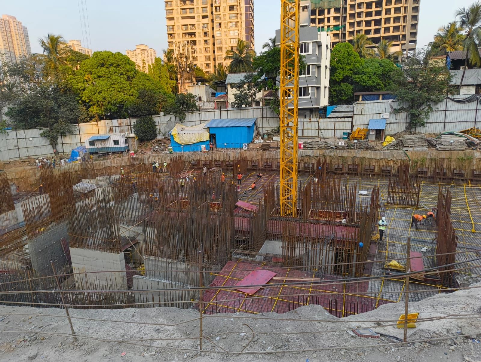 High-rise building under construction with scaffolding and safety nets.