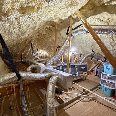 Insulated attic with ductwork and storage bins.