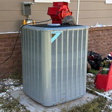 A Daikin air conditioning unit installed outside a house.