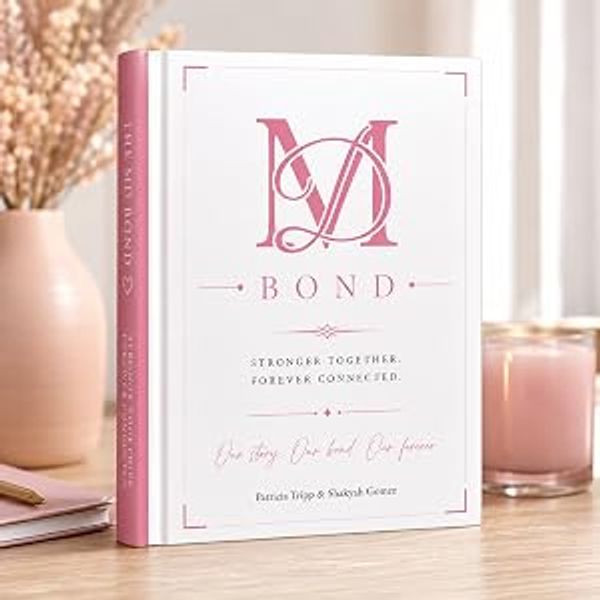 Elegant book titled 'BOND' with pink and white cover on a cozy table.