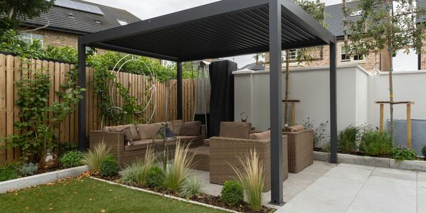 Modern outdoor seating area under a pergola in a cozy backyard.