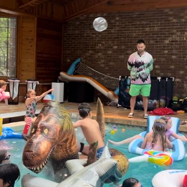 A group of people playing with a ball in the swimming pool. 