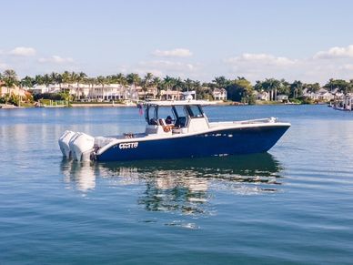 Blue motorboat on calm water near houses.
