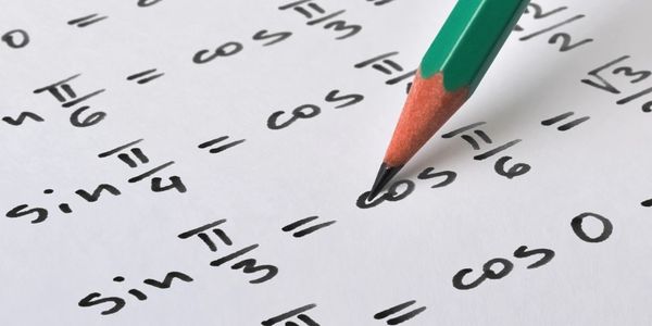 A green pencil writing trigonometry (sin, cos, tan) functions.