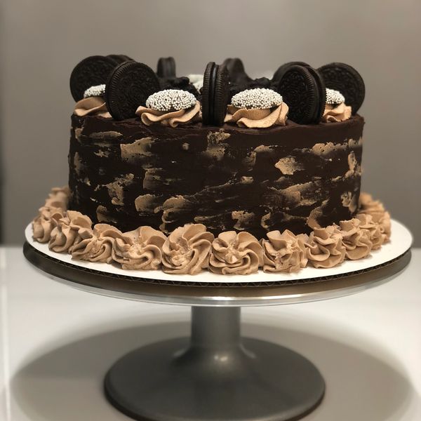 Chocolate cake decorated with Oreos and cream swirls.