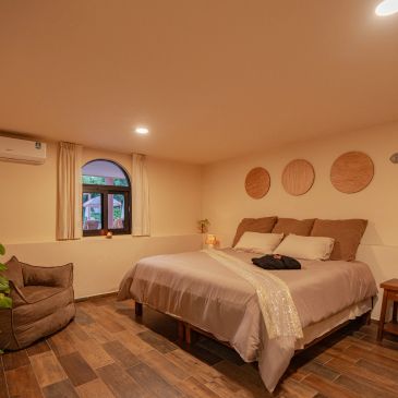 Cozy bedroom with warm lighting and wooden floor.
