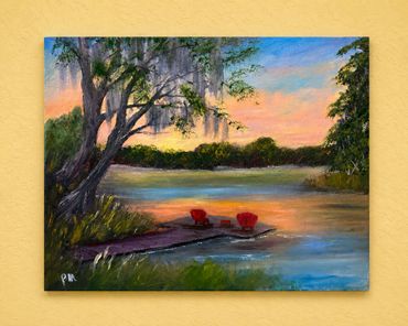 Serene lakeside sunset with two red chairs on a wooden dock.