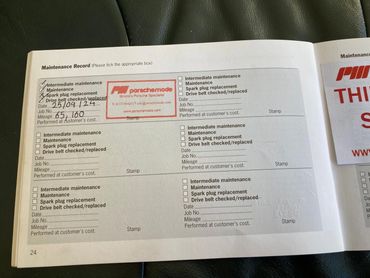 A vehicle maintenance record booklet showing completed services.