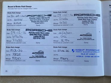 A filled brake fluid change record booklet for a Porsche car.