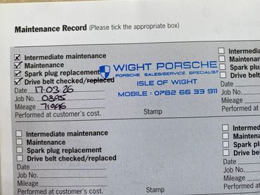 Maintenance record form with stamps and check marks for intermediate maintenance and spark plug replacement.