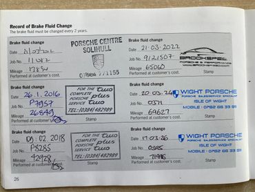 Car brake fluid change record with dates, mileage, and service stamps from Porsche Centre Solihull and Wight Porsche.