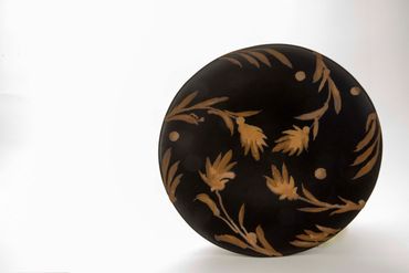 Decorative black plate with gold floral pattern.