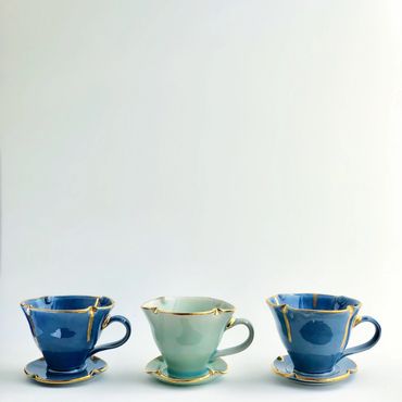 Three ceramic cups with gold accents.
