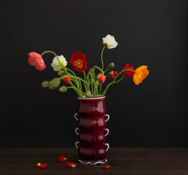 Colorful flowers in a red vase.