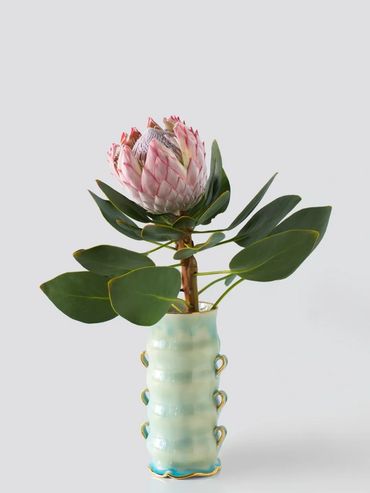 A pink flower in a decorative vase.