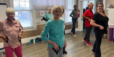 Group of diverse adults exercising indoors with resistance bands.