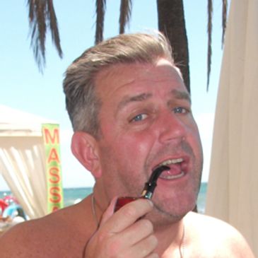 Man smoking a pipe near the beach.