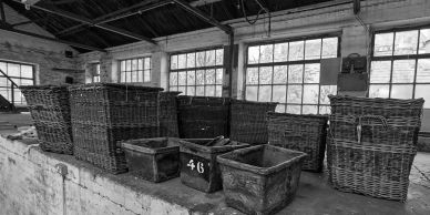 Old baskets and crates lined up on a concrete surface.