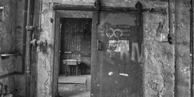 Old, worn-down metal door in a dilapidated building.