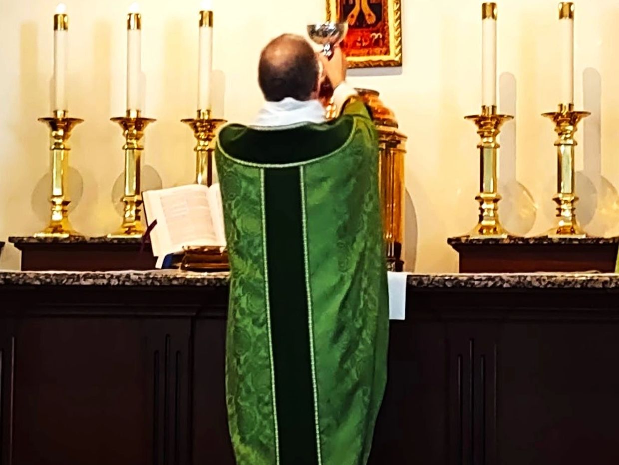 Fr Hines consecrating the wine