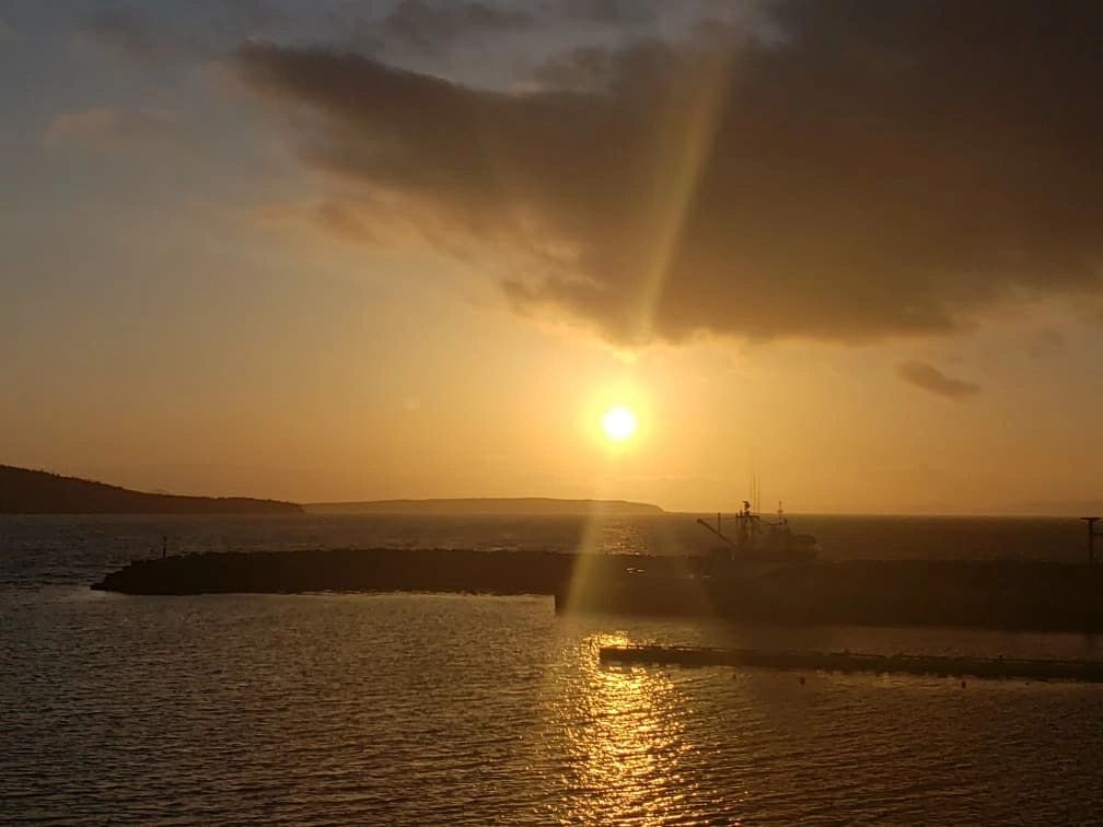 View of an ocean landscape at sunset overlooking a wharf in Whiteway.