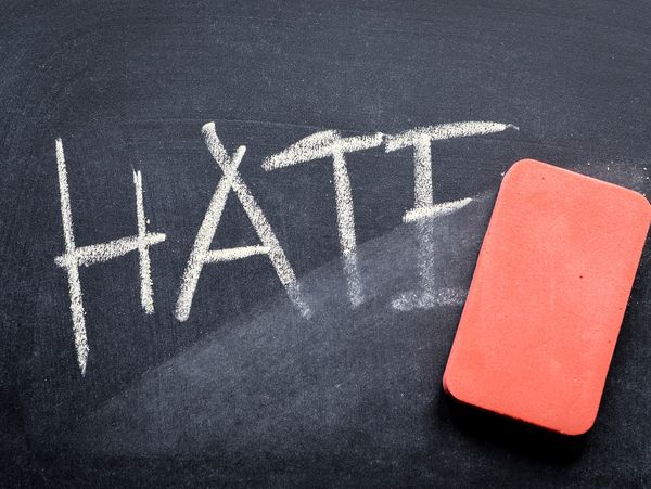 Picture of a blackboard with the word "HATE" being erased.
