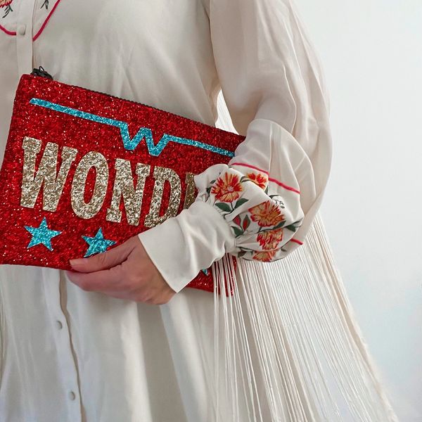 Girl holding wonder glitter clutch bag. 