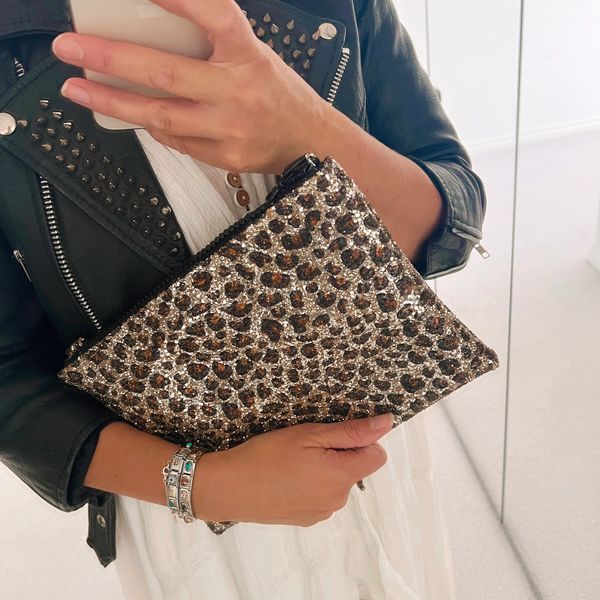 Girl holding a glitter leopard print bag. 