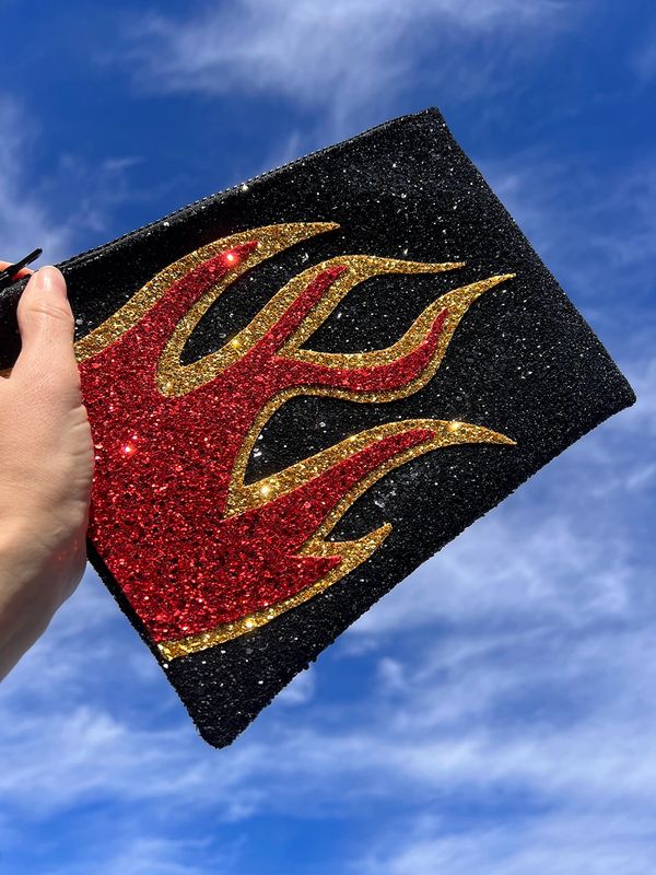 Flame glitter clutch bag held up to sky. 